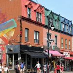 Une scène de rue à Montréal avec une peinture murale sur le côté d'un bâtiment, parfaite pour les expériences en petits groupes.